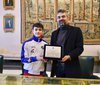 Andrea Bertasi - consegna del riconoscimento da parte dell'ass. F. Carità - foto FVecch